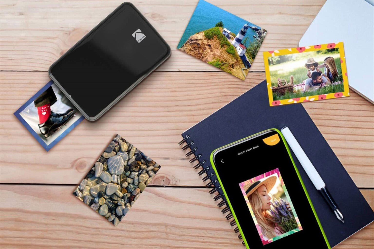 Product photo of the Kodak Step instant smartphone photo printer with printouts.